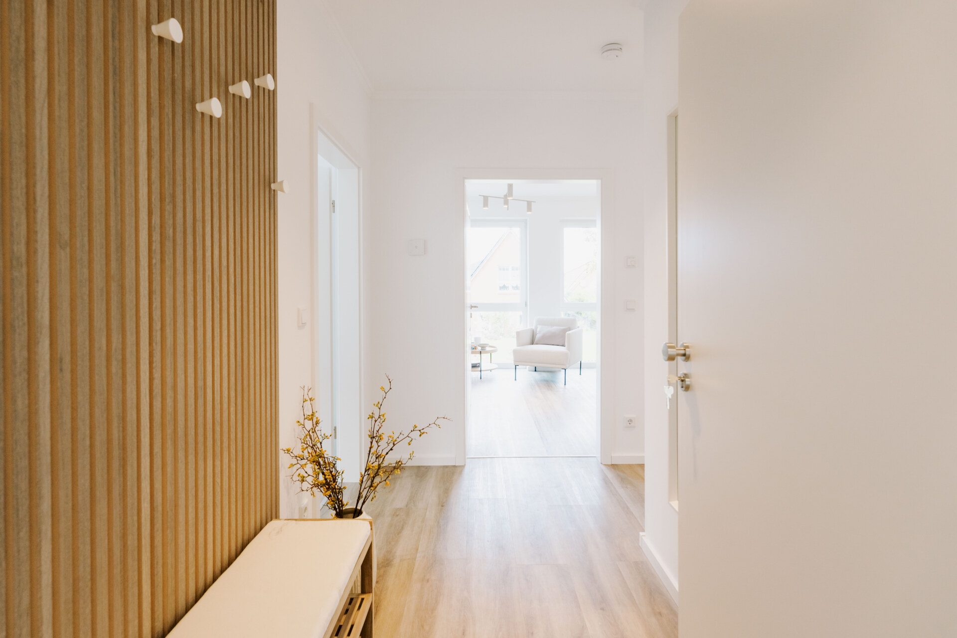 Heller Flur und Wohnbereich einer im nordisch-skandinavischen Stil eingerichteten Ferienwohnung von Küsten Suites
