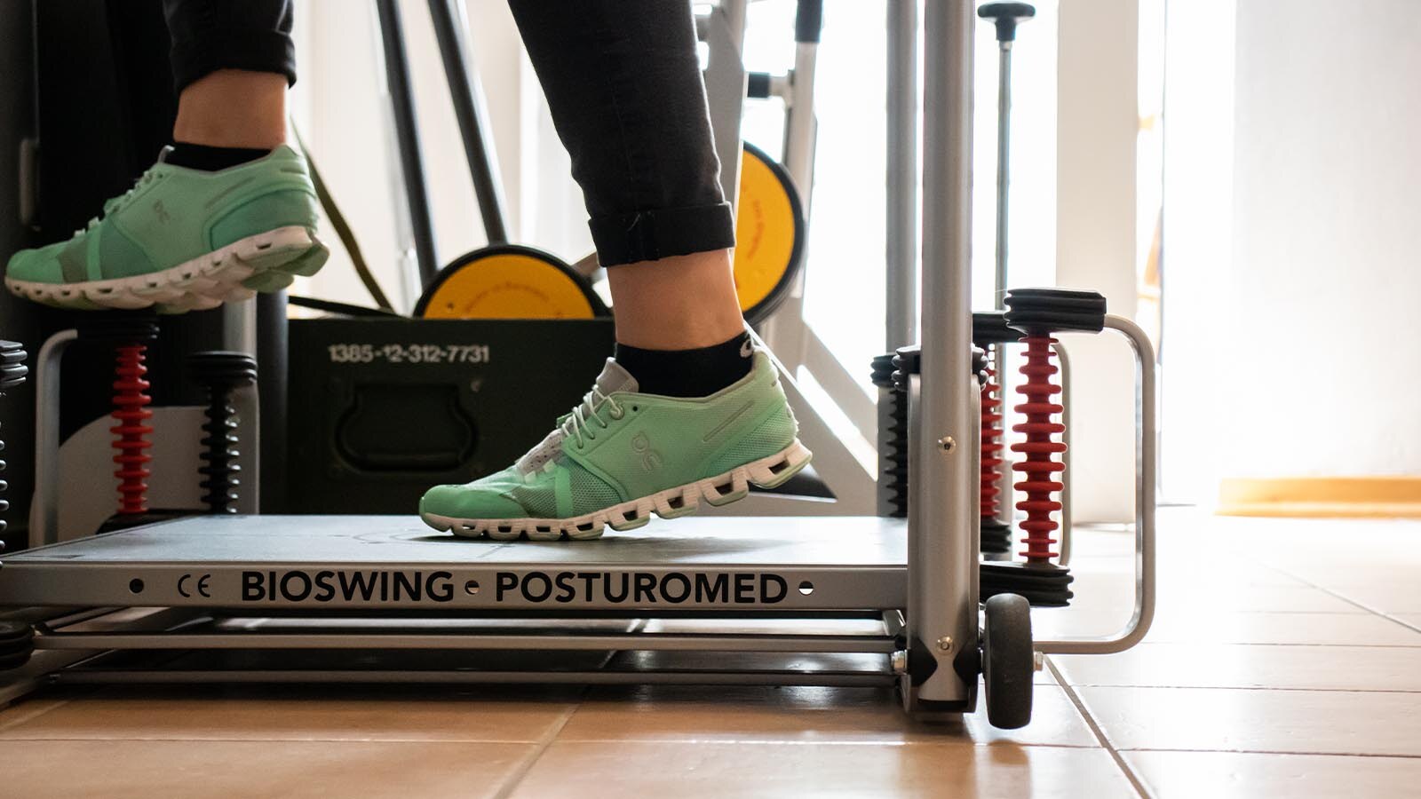 Physiotherapeutin begleitet eine Patientin beim Training auf dem Posturomed im Trainingsraum des PhysioZentrums Aurich