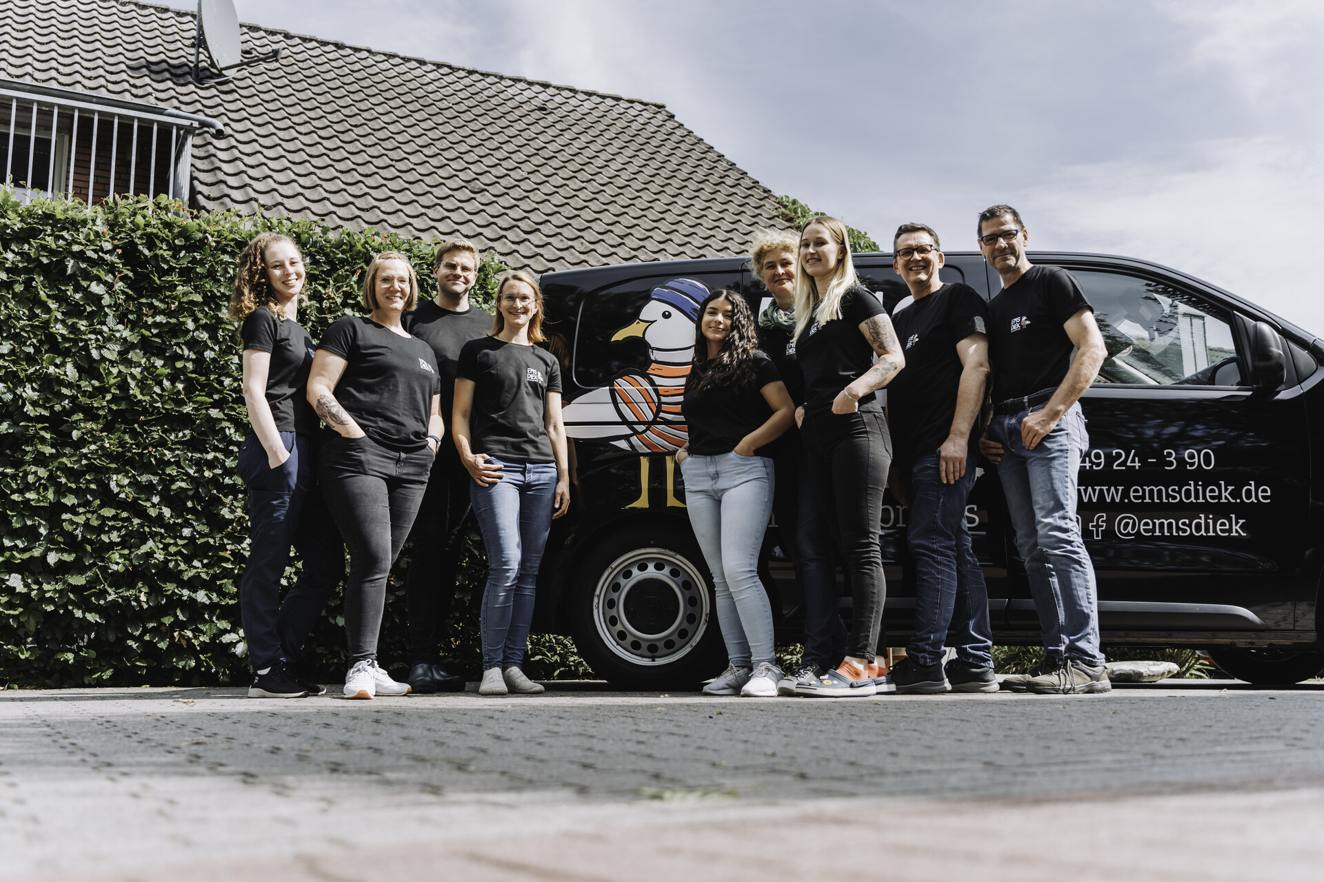 Das Team der Tierarztpraxis Emsdiek vor dem schwarz folierten Praxistransporter mit Möwen-Logo